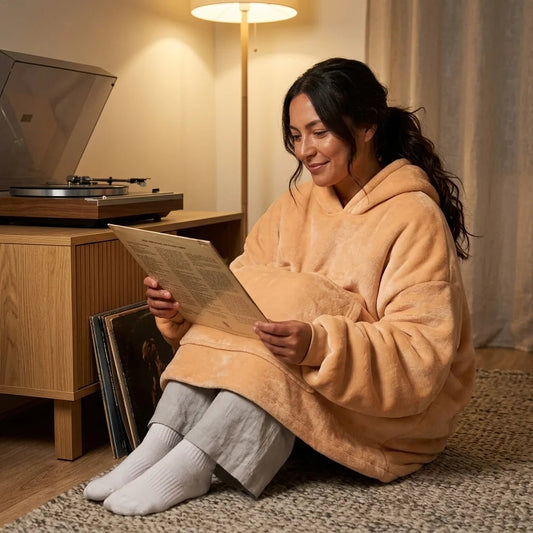 Woman in the Apricot blanket hoodie looking through vinyl records on the living-room floor in the evening