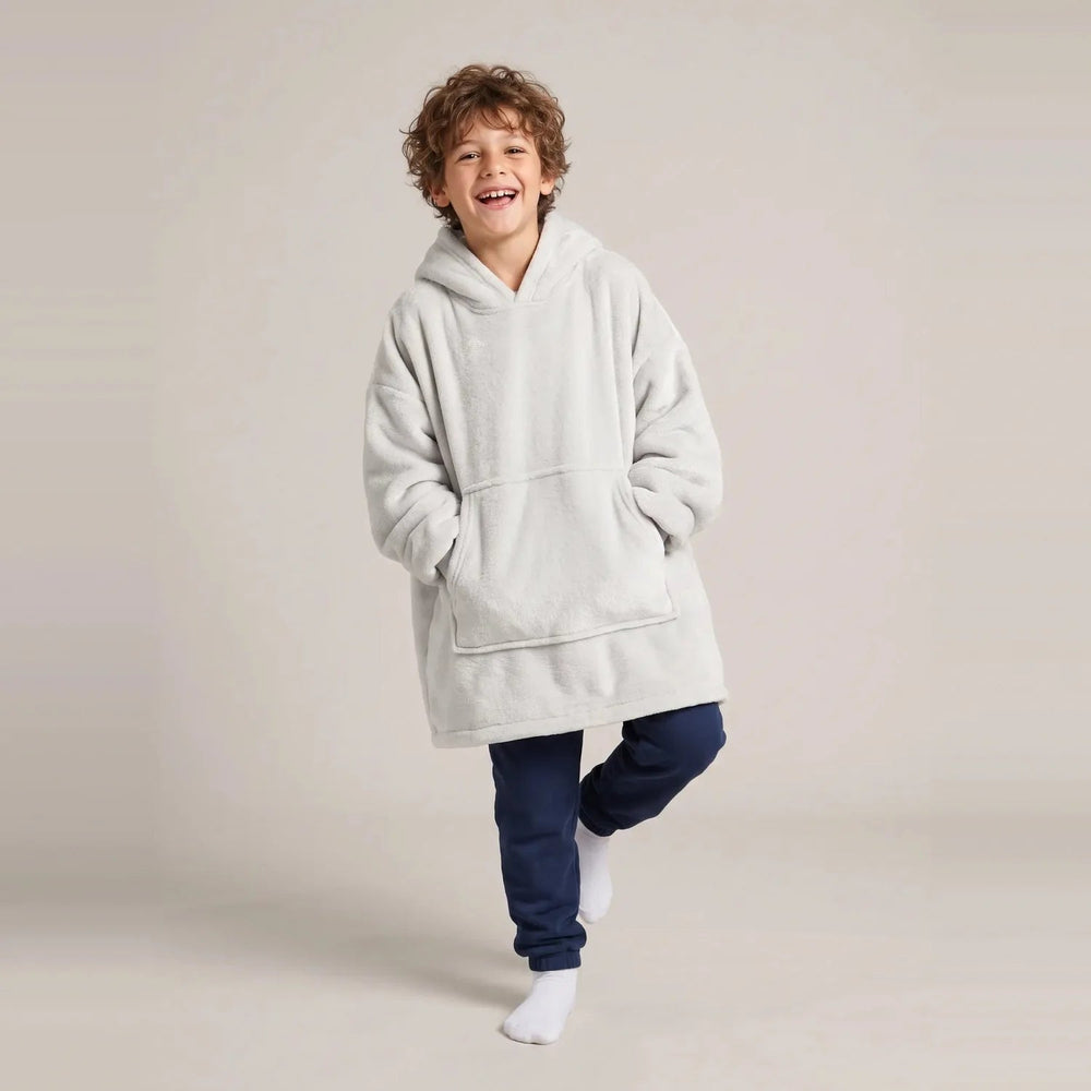 Child wearing the Light Gray Kids blanket hoodie, studio photo